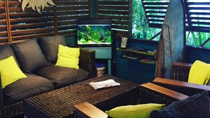 A cozy seating area with a sofa and chairs, a small table, and a fish tank. - Hotel les Bougainvilliers (Saint-Paul)