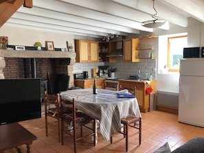 A cozy kitchen with a dining table, chairs, a TV, and a refrigerator. - House / Villa - Larmor Plage (Larmor-Plage)
