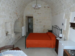 Cozy retreat with a single bed, nightstand, and small table, featuring a simple design and a separate bathroom.