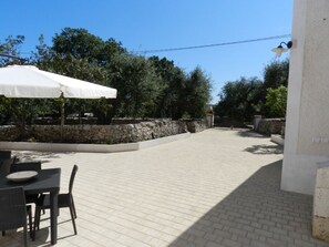 Relax in a serene outdoor patio surrounded by lush greenery and a charming table setting.