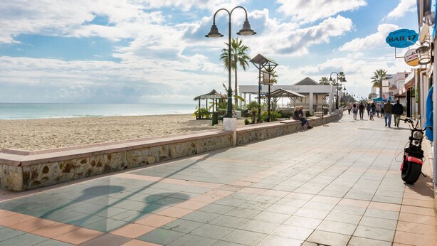 A beachside promenade with a tiled walkway, palm trees, and a view of the sea. - SF CARIHUELA LUXURY SUITE (Torremolinos)