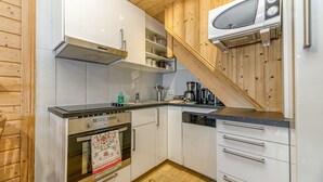 A modern kitchen with white cabinets, stainless steel appliances, and wooden accents. - LES ARCS1950 Very confortable apartment, Southview, snow sure, Indoorpool, Sauna (Bourg-Saint-Maurice)