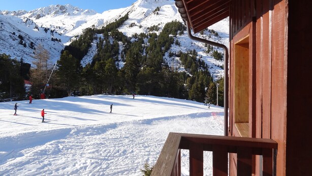 A wooden cabin with a snow-covered mountain backdrop, ski slopes, and a clear sky. - LES ARCS1950 Very confortable apartment, Southview, snow sure, Indoorpool, Sauna (Bourg-Saint-Maurice)