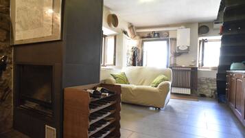 Ein Wohnzimmer mit Kamin, einer Couch und einem Weinkühlschrank.