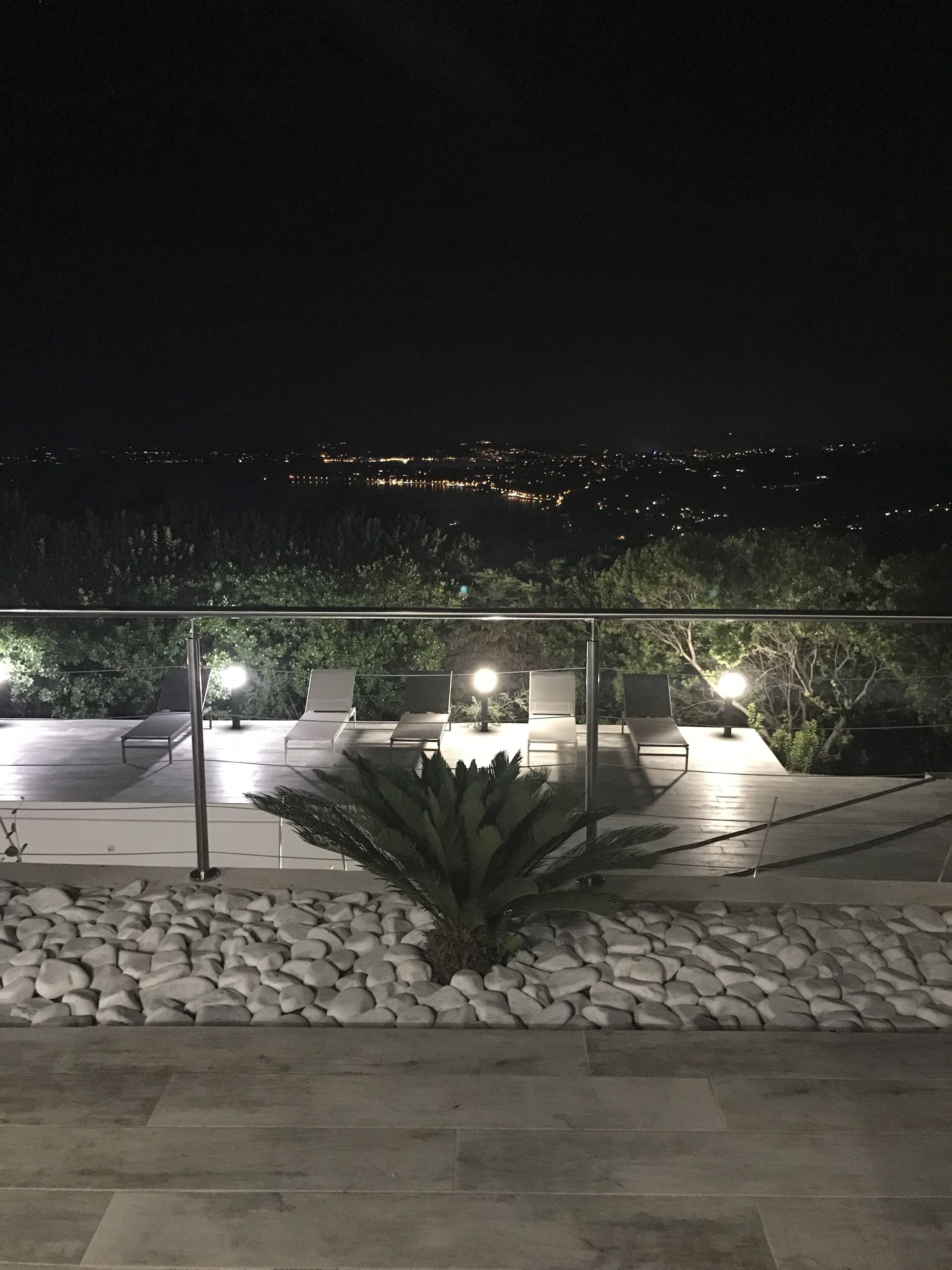 Zona relax esterna con poltrone e tavolo, circondata da un basso muretto in pietra e un'ampia pianta di agave.
