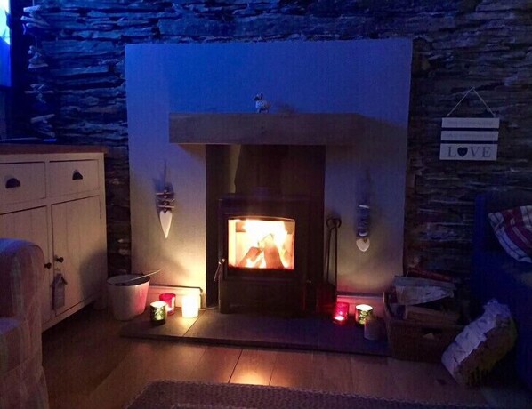 Cozy room with a fireplace, sconces, and a small table with a candle.