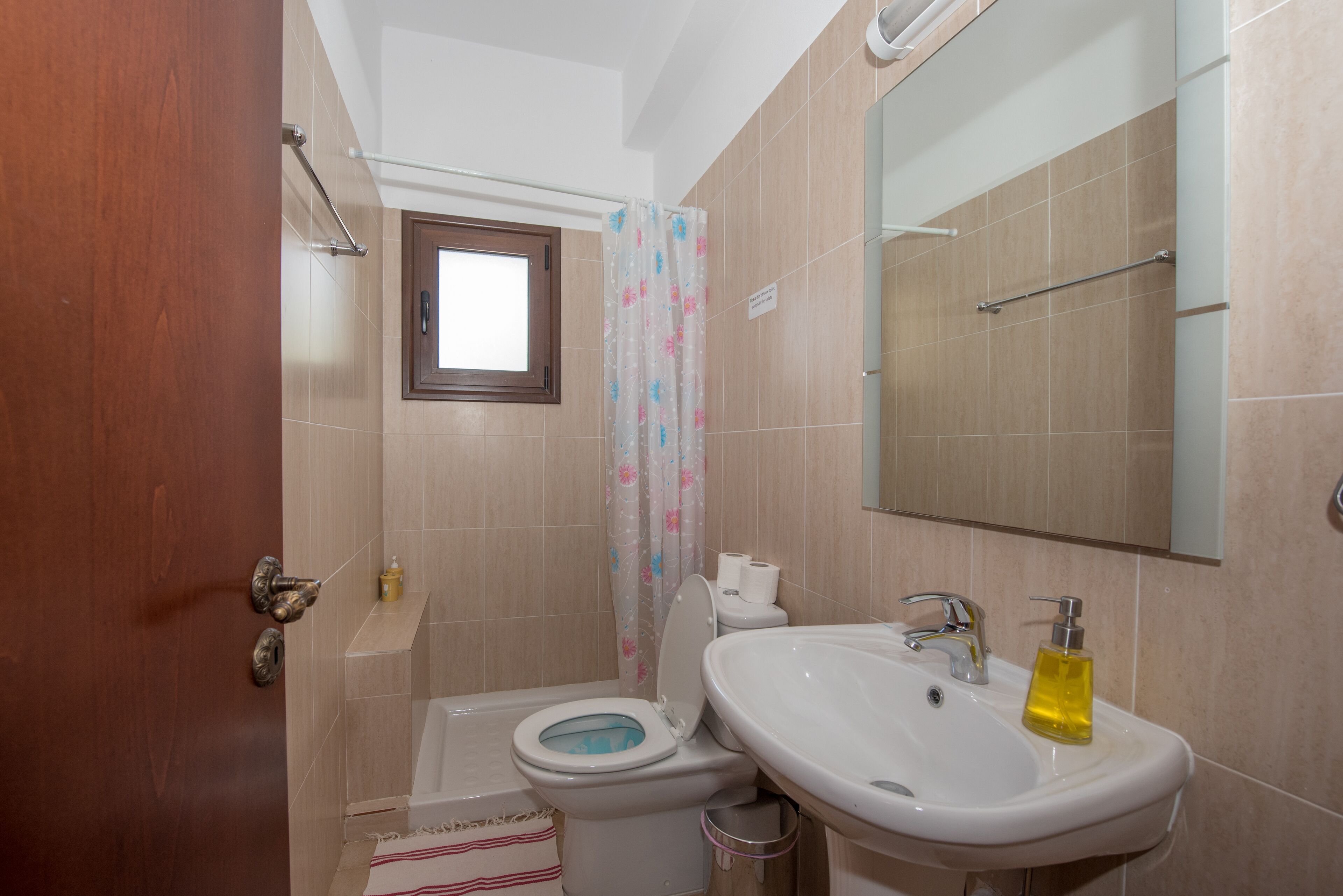 A bathroom with a toilet, sink, and shower.