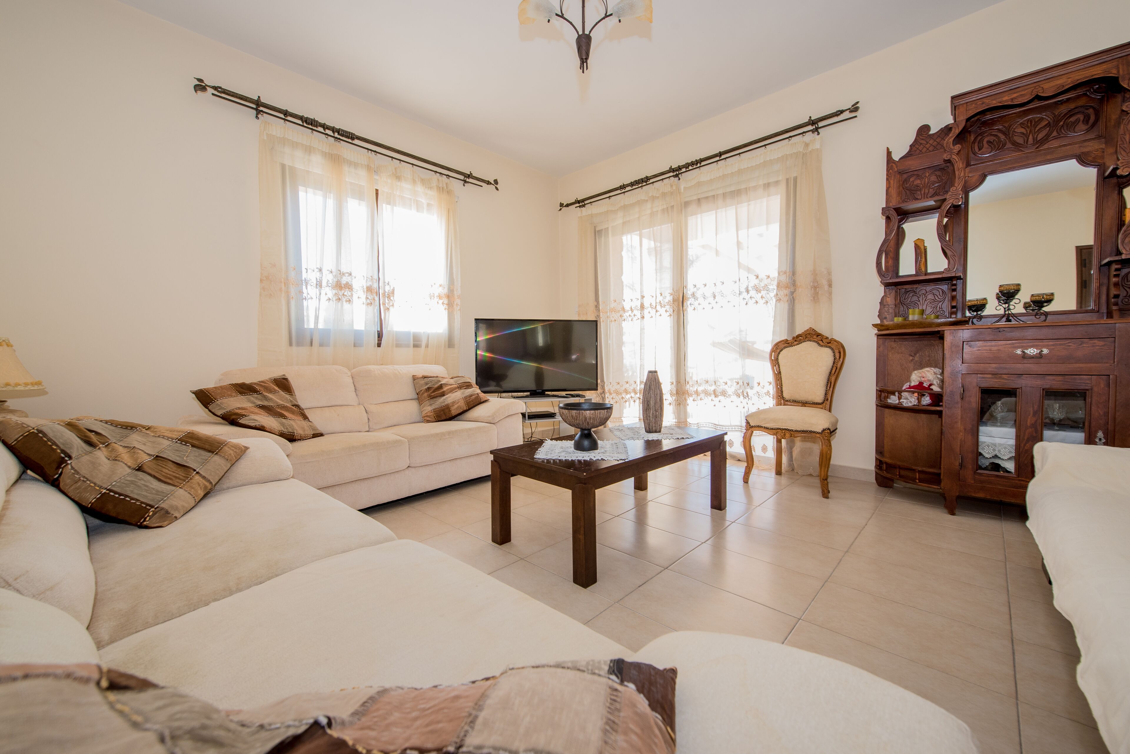 A living room with a sofa, a coffee table, a TV, and a cabinet.
