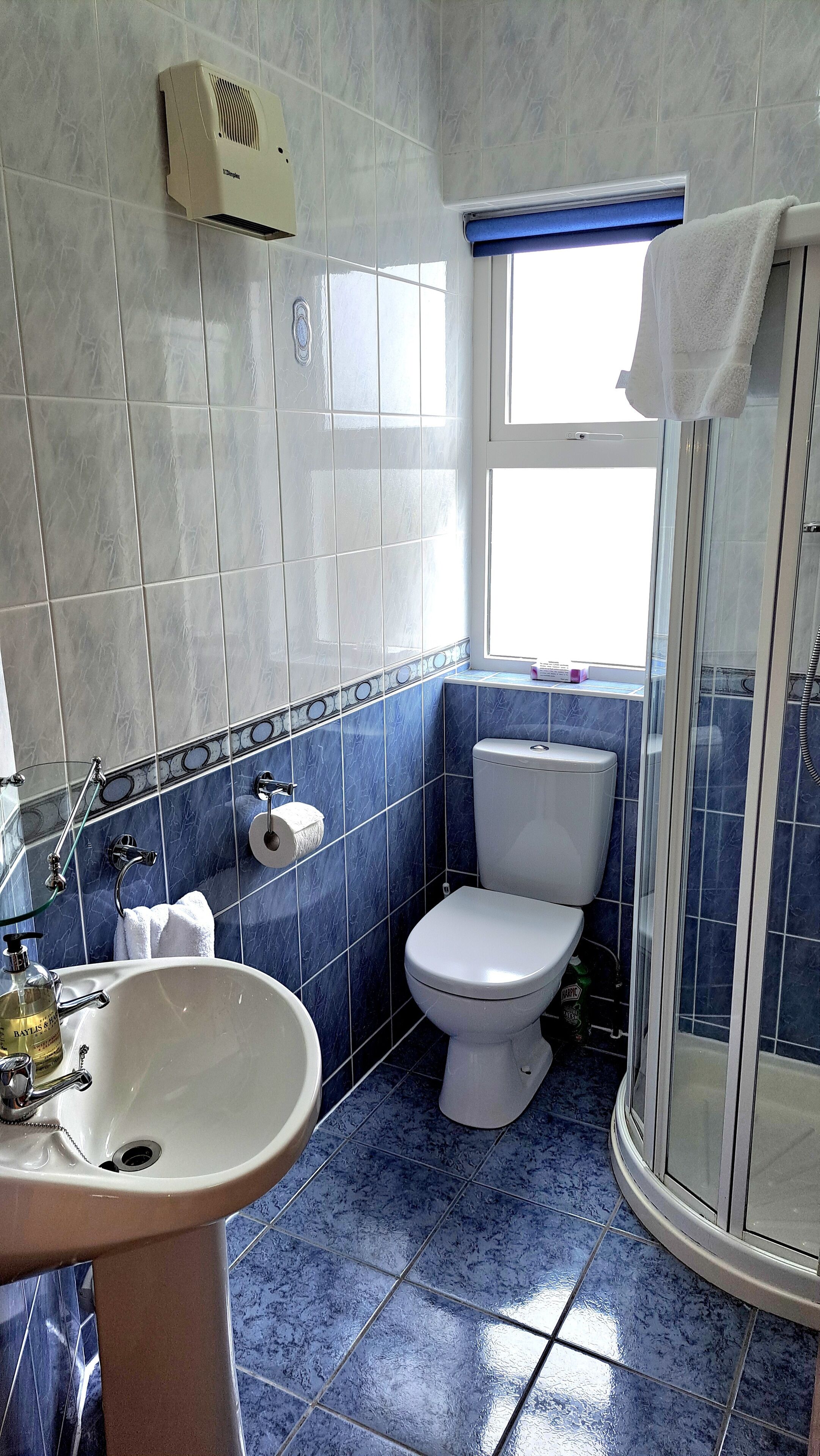 A bathroom with a toilet, sink, and shower.