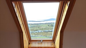 A room with a sloped wooden ceiling and a skylight. - Luxury Connemara Cottage With Panoramic Views Of The Sea And Mountains  (Rosmuc)