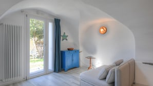 Ein gemütliches Zimmer mit einem weißen Sofa, einer blauen Kommode und einer Meerstern-Dekoration an der Wand.