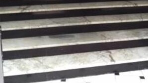 Eine Treppe mit Handlauf und einer Tür am oberen Ende.