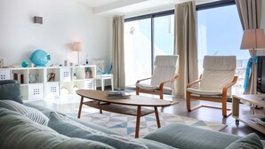 A modern living room with a sofa, two armchairs, a coffee table, and a bookshelf. - Beco do Poço - Praia da Luz (Luz)