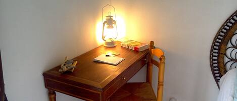 Una scrivania in legno con una lampada, un libro e una penna.