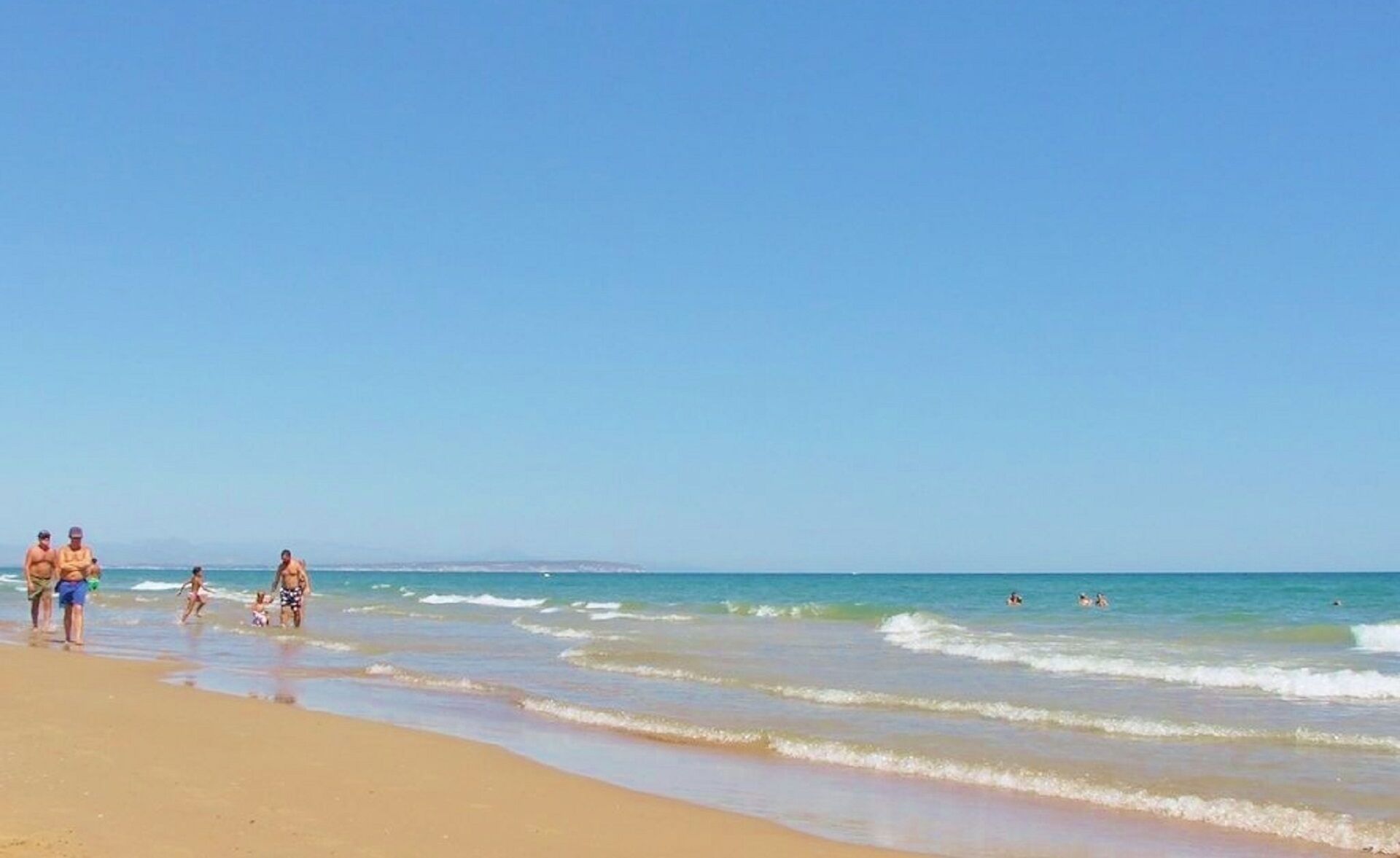 A beach with clear skies and calm waters.