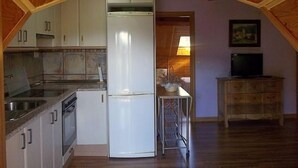 A compact kitchen with white cabinets, a refrigerator, and a sink. - Maribel Tourist Apartment for 5 people (Biescas)