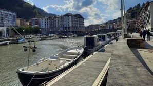 A marina with boats docked, a wooden walkway, and buildings in the background. - FLAT in the CENTER OF ONDARROA, fishing village, with WIFI 600MB, without slopes. (ONDARROA)