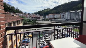A balcony with a view of a parking lot, buildings, and a bridge. - FLAT in the CENTER OF ONDARROA, fishing village, with WIFI 600MB, without slopes. (ONDARROA)
