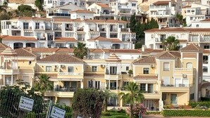 A densely packed residential area with multi-story buildings, featuring balconies and a Mediterranean architectural style.