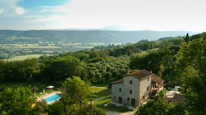 A stone building with a swimming pool, surrounded by lush greenery and hills in the background. - Casale in Teverina - Entire house in countryside (Penna In Teverina)
