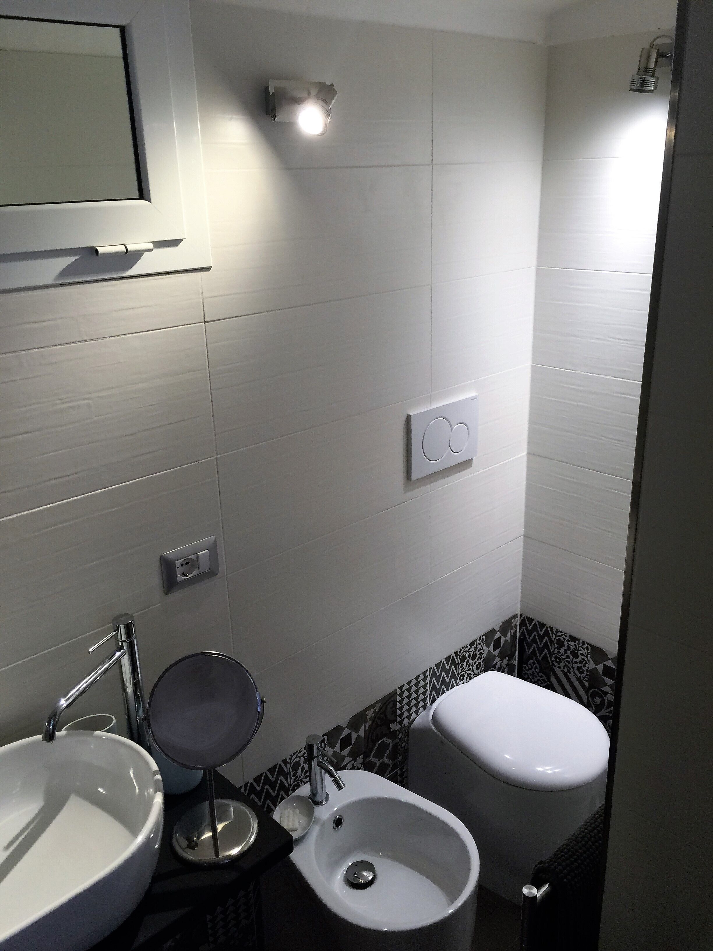 Un baño con lavamanos, inodoro y ducha.