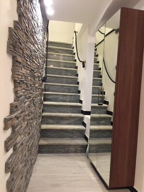 A staircase with a stone wall on one side and a mirrored wall on the other. - Monterosso al Mare 5 Terre - XX Street - To live an unforgettable experience ... (Monterosso al Mare)