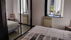 A bedroom with a bed, a chair, a window with curtains, and a radiator. - House 6 people, large volumes and large garden  (Saint-Lizier)