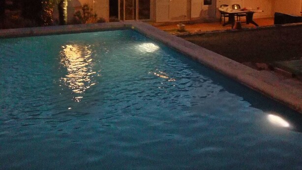 Piscina com uma casa ao fundo.