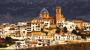 Poble històric amb una església destacada que presenta una cúpula i un campanar.