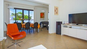 Una cocina moderna con comedor, televisor y vistas al exterior.