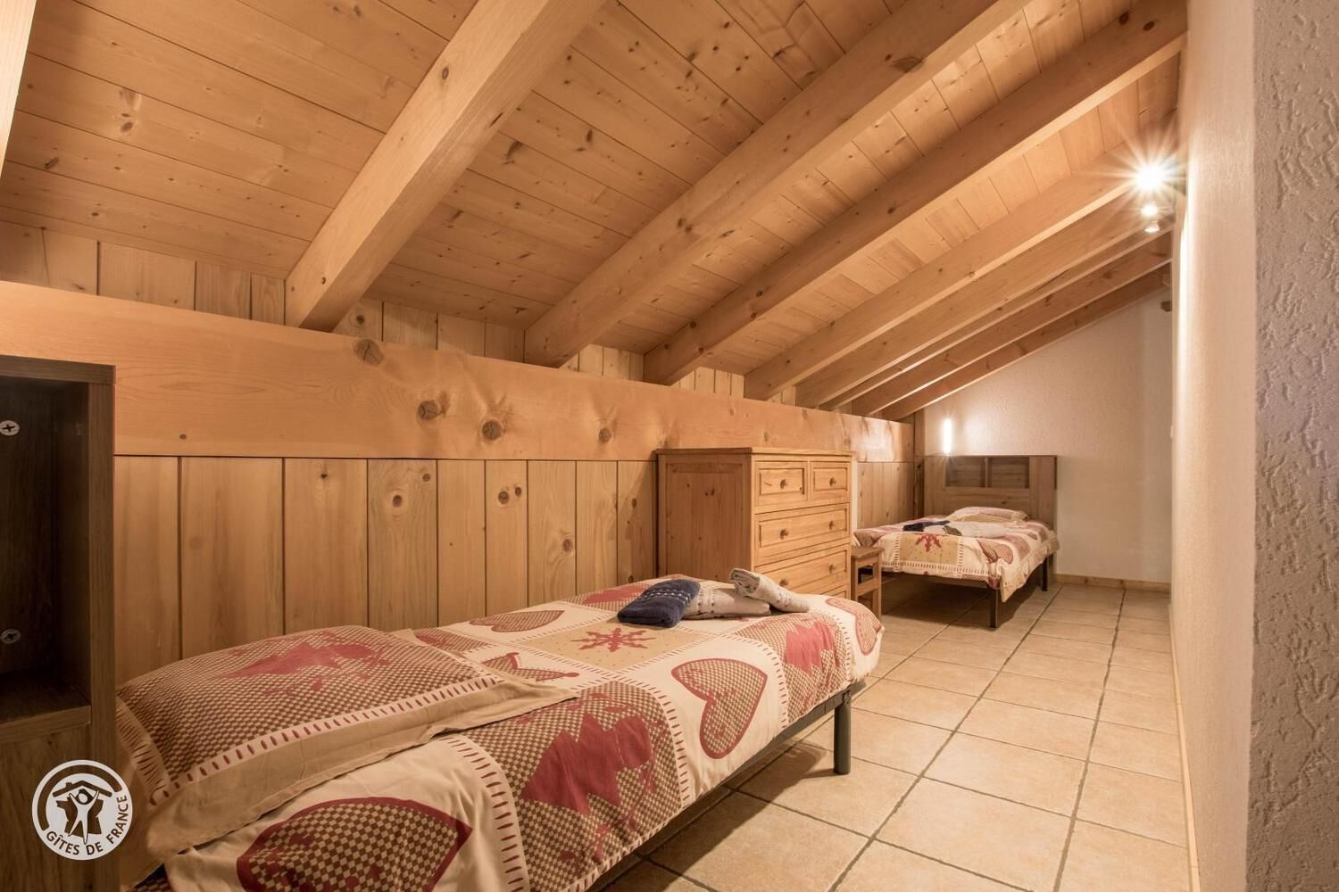 Ein Zimmer mit Holzboden, zwei Betten und einem Schminktisch.