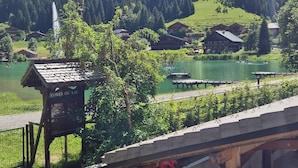 A mountain landscape with a lake, a wooden structure labeled 'LOREE DU LAC,' and a bridge.