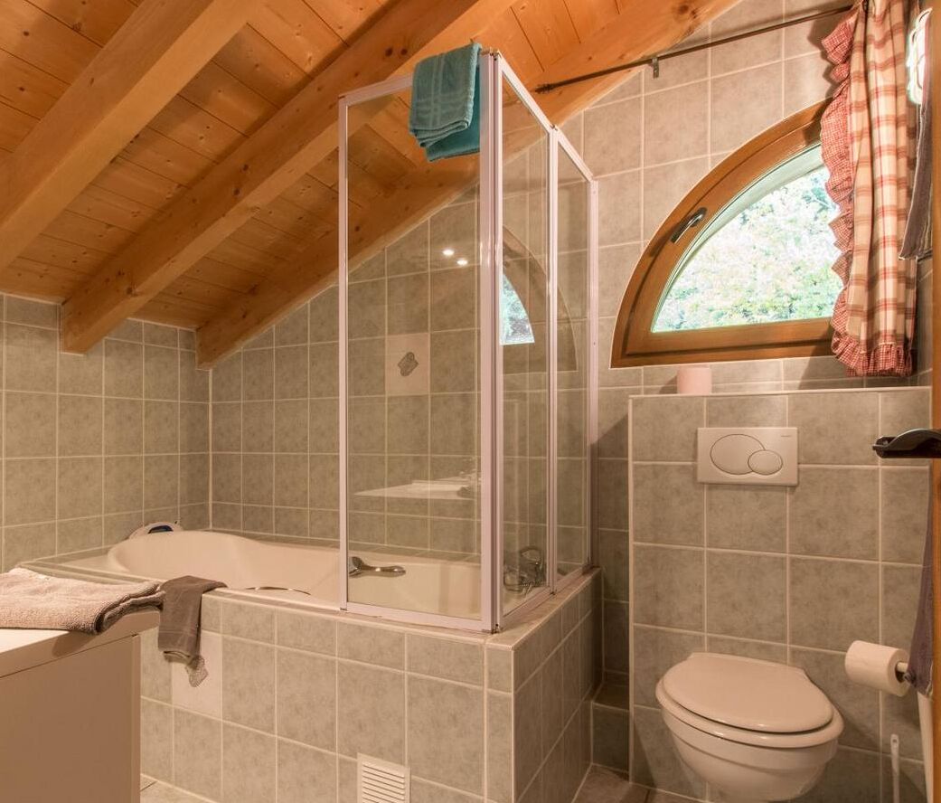 A bathroom with a bathtub, a shower enclosure, and a toilet.