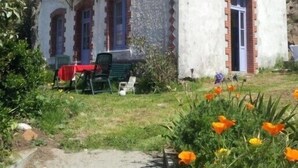 A two-story building with a balcony, a red table, and chairs outside. - The Port of Millstone, island of Yeu, house with garden pets allowed (L'île-D'yeu)