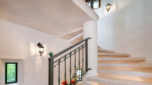 A staircase with a white railing and a potted plant.