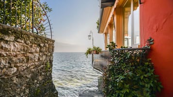 Un mur de pierre menant à un balcon d’où l’on peut admirer la mer.