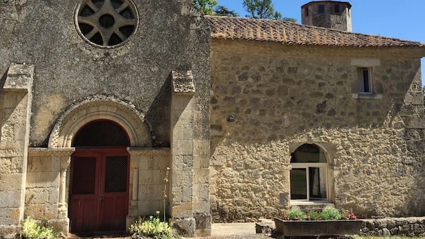 A historic stone building with a prominent tower featuring arched windows and a circular window. - Charming property with its chapel and towers (Lannes)