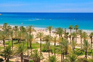 A beach with palm trees and a clear blue sea.