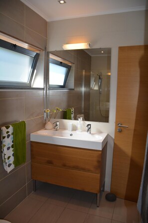 A modern bathroom with a large mirror, two sinks, and a shower. -  AtlanticWindow - Modern House, Stunning View (São Roque do Pico)