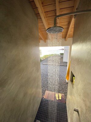 A shower area with a rain showerhead, a wooden floor, and a view of the outdoors. -  AtlanticWindow - Modern House, Stunning View (São Roque do Pico)