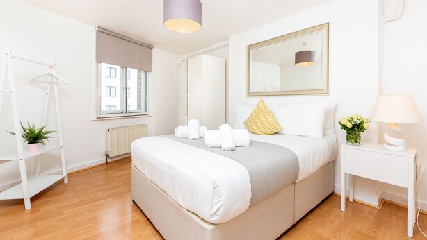 A modern bedroom with a bed, bedside table, and a hanging light fixture. - PRIVATE APARTMENT - HEART OF SHOREDITCH (London)