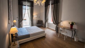 A bedroom with a bed, desk, chair, lamp, and curtains. - Largodonnaregina home vacation home 2 bedroom apartment historic center (Napoli)