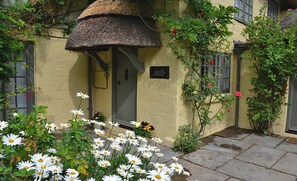 A cottage with a thatched roof, a door, and a sign reading 'BECK COTTAGE.' - Beck Cottage New Forest (Fordingbridge)