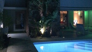 Una casa moderna con piscina, patio e interior bien iluminado.