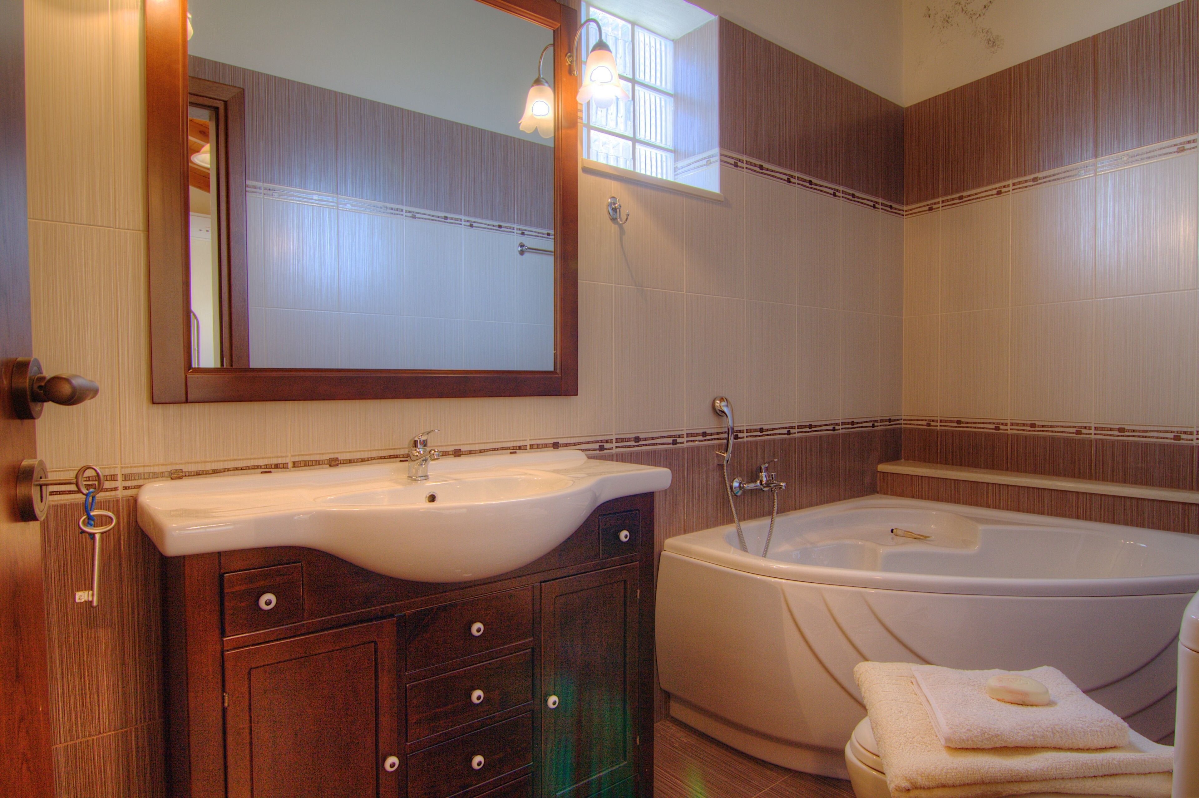 Une salle de bain équipée d’un lavabo, d’un miroir, d’un meuble-lavabo et d’une baignoire.