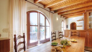 Una mesa de madera con platos de comida, una botella de aceite y una ventana con cortinas.