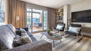 A modern living room with a sofa, armchair, coffee table, and a flat-screen TV. - Puente Romano Phase 2, Golden Mile, Marbella (Marbella)