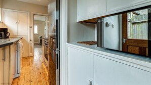 A modern kitchen with white cabinets, stainless steel appliances, and a wooden floor. - Lavender House | Oxford Holiday Let | 2 Bed & Sleeps 4 (Oxford)