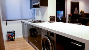 A compact kitchen with a washing machine, a dishwasher, and a small trash bin. - Fantastic Apartment in The City of Arts and Sciences (València)