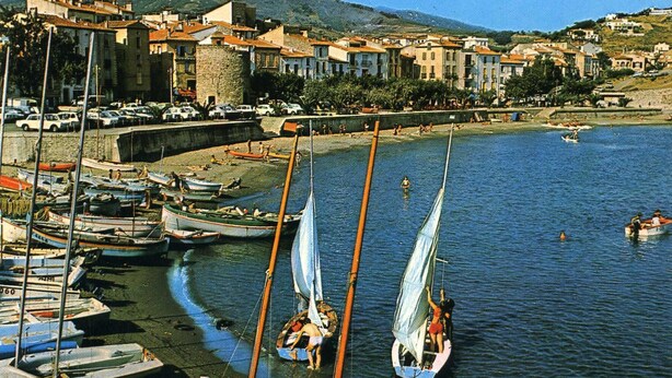 A coastal town with boats docked along the shore, a sandy beach, and buildings in the background. - House with character of  a fisherman (Collioure)